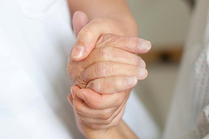 Eine Hand hält eine andere Hand fest.